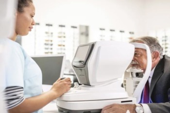 A woman looks into a machine in an eye clinic